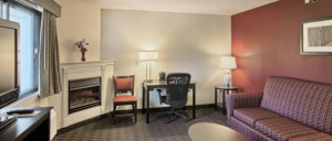 Well-furnished Blossom Hotel & Suites' room featuring a couch, chair, and TV for relaxation.