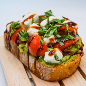 Thick multigrain toast piled high with southwest guacamole, cherry tomatoes, mozzarella cheese, balsamic glaze, and basil.