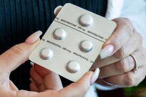 Image of woman showing abortion pills Mifepristone and Misoprostol