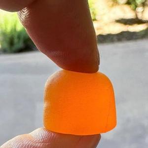 Photo of person holding a bright orange Deep Sleep Gummy