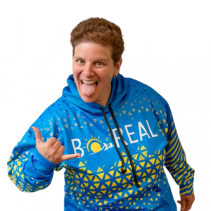 Image shows woman smiling at camera wearing blue and yellow hoodie