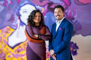 Husband and Wife Cofounders Christopher and Liesl Perez are pictured side-by-side in front of a mural.