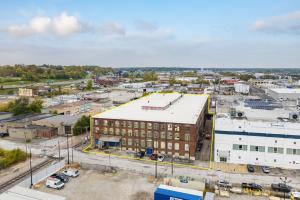 Building is a red brick three story with a new white membrane ceiling. There are multiple docks and street parking.