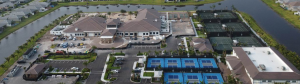 Aerial view of the nearly completed clubhouse at Valencia Grand by GL Homes in Boynton Beach, Florida, featuring extensive facilities such as tennis and pickleball courts, landscaped grounds, and nearby water features, highlighting the luxurious amenities