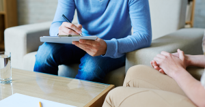 A therapist takes notes during a session