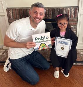 Michael Michie and daughter hold an award from Literary Titan.