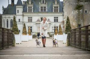 Shannon Pratuch at Château de Chenonceau with her two French bulldogs, castle in the background.