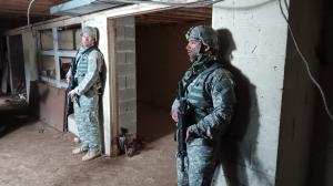 Two American Soldiers about to scope out a hallway in an abandoned warehouse.