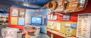 An exhibit in Dossin Great Lakes Museum showcasing a boat along with other historical maritime artifacts.