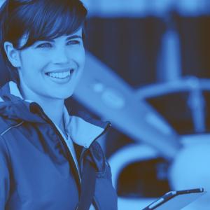 A woman preparing for flight in front of a small plane