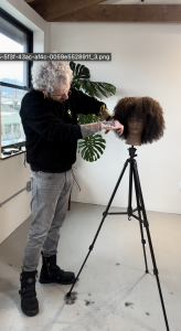 taglio su testina modella con capelli afro molto ricci