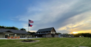 Image of Boulder Crest Texas at Sunset with the Texas and American Flags