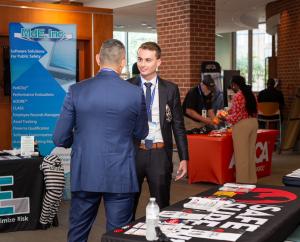 Graeme Page engaging with attendees at the Safe Surfin' Foundation booth during the 2024 SRLEEA Annual Conference.