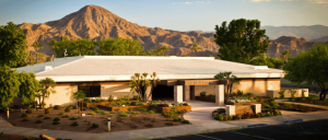 A scenic view of a desert oasis resort featuring a pool and palm trees.