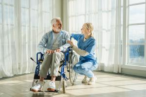 patient in a wheelchair with a caring doctor next to him