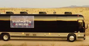 A bus sits on the road in the desert.