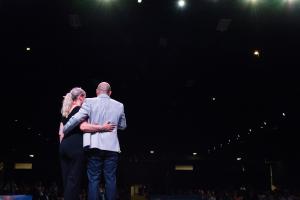 Co-Founders Lee-Ann and Jamie Prickett on stage facing a large audience at Experior Financial Group's Decade of Distinction Convention in Toronto