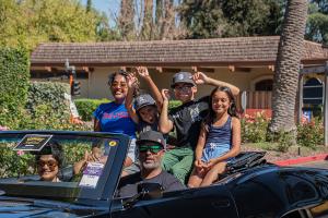 People riding in a vintage convertible