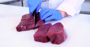 A Sustainable Meats employee portion cuts filets