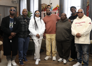 An image capturing Muni Long at a listening party for her upcoming album, alongside key figures in the music industry. The group includes Grammy-winning producer Bryan-Michael Cox, manager Chaka Zulu, Def Jam CEO Tunji Balogun, manager Jeff Dixon, Def Jam