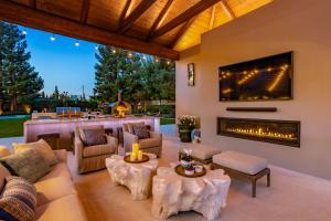 Wendy Glaister's Outdoor Oasis features a beautiful outdoor living space with custom outdoor upholstery that sits in front of the linear gas fireplace and large TV's that are mounted to either side of pergola structure.