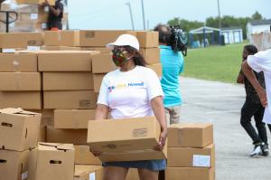 Volunteer load food box in vehicle.