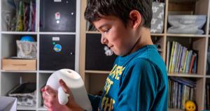 A young boy meets Snorble®, a child's smart companion, for the first time while holding them in their hands.