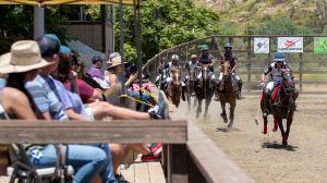 arena polo players race for the ball as a group of spectators look on