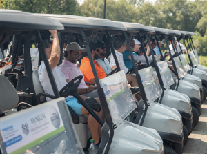 Golf carts lined up at the 2024 Markham Board of Trade Corporate Charity Golf Classic, filled with participants ready to start. Beverage Cart sponsor, Minken Employment Lawyers, are displayed on the carts.