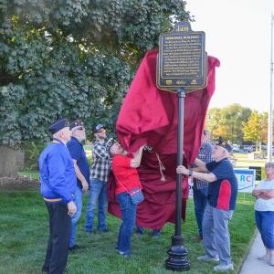 Members of the American Legion Post 19 unveil the Historic marker in front of the Lehi Memorial Building.