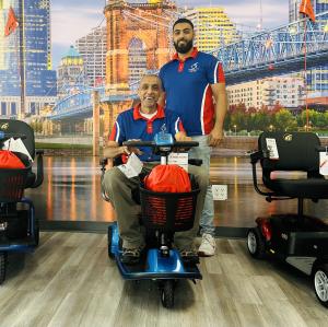 Photo of Mobility City Cincinnati owners Wally and Abdallah Othman in front of their Cincinnati wall mural