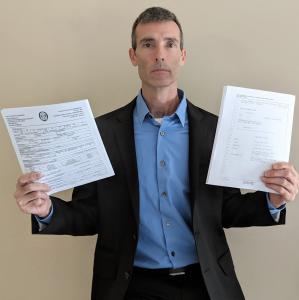 SubscriberWise founder and America's child identity guardian David Howe, holding two public records each containing sworn testimony which has been provided to USA Congress, law enforcement, and media confirming profound consumer UDAAPs.
