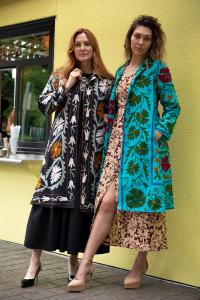 Two women wearing Transcend's Malika Coats