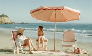 People at the beach in chairs with an umbrella