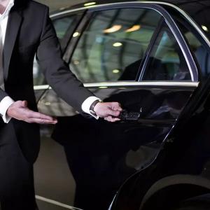 a chauffeur open the door of luxury limo