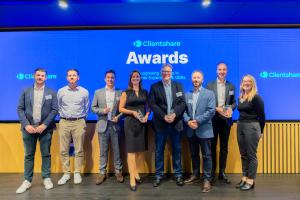 A photo showing the winners of the 2024 Clientshare Awards standing on a stage with the Clienthsare logo behind them, and the statement: 'Recognising leaders in Customer Experience & QBRs'