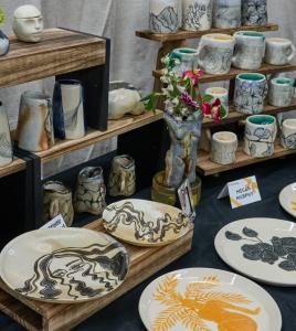 A display of ceramic mugs, bowls, and plates by a local NY artist.