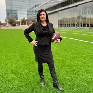 Criminal Defense Attorney Heather J. Barbieri holding a football at the new Barbieri Law Firm Headquarters at The Star in Frisco.