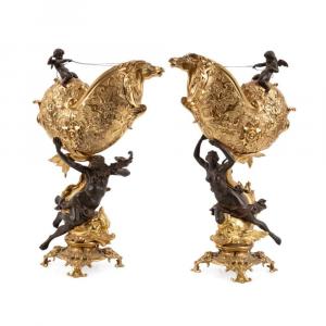 Pair of 19th century French patinated and gilt bronze marine motif table garnitures, modeled as Poseidon and Amphitrite riding dolphins, each holding aloft a nautilus shell driven by Cupid ($5,445).