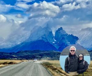 A road with a lone yellow car heads toward the deep blue Towers of Paine mountains on a cloudy day. An inset to the figure shows Chip Walter and Cyndy Mosites in coats in front of a lake