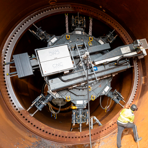 The  precision machine is seen milling CS WIND Offshore's large diameter flanges. A man standing beside shows the scale and size of the transition piece