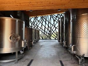 Stainless steel wine tanks at Puerta del Lobo Winery with a view of the El Lobo Valley in Querétaro, Mexico