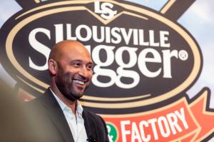 Derek Jeter smiling under Louisville Slugger Logo on wall