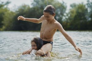 Image of two young people playing in a lake