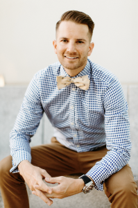Dr. Tyler Hales sitting wearing a fashionable outfit and bowtie