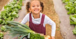 Young girl picking produce in the garden