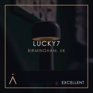 This image showcases a sleek and modern design for a bar or establishment named “Lucky 7,” located in Birmingham, UK. The use of minimalistic elements, such as the lamp featured in the foreground, paired with a sophisticated colour palette, gives it an el