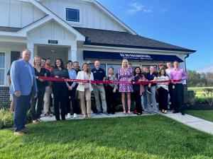 Guests and employees standing in front of model home at ribbon cutting ceremony