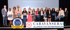 Group of people on stage at a 'Caravanserai Alliance for Entrepreneurs' event holding certificates.