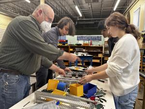 a teacher helps students with a robot